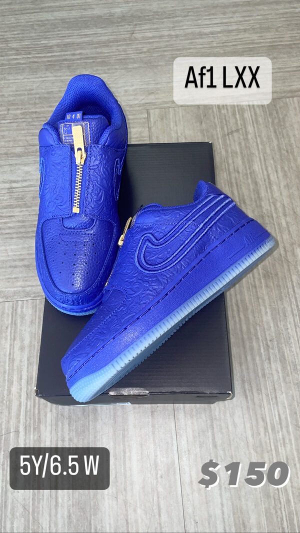 A pair of blue Af1 LXX sneakers on a box, displayed on a wooden floor with size and price label visible.
