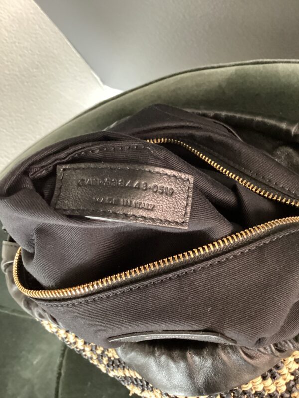 Close-up of an open Cole Haan Bag showing an interior label with text and a serial number, marked "Made in Italy.