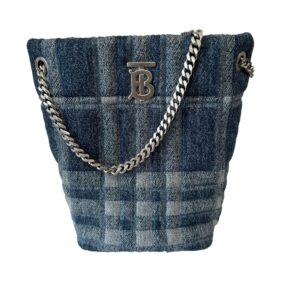 Burberry bucket bag with a plaid pattern, featuring a silver chain strap and a metal logo clasp, isolated on a white background.