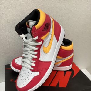 A pair of red, yellow, and white Jordan 1 Bright Pink sneakers displayed on a Nike box.