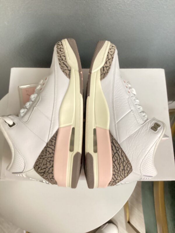 Pair of white high-top sneakers with light pink and beige accents, displayed on a box with visible animal print design.