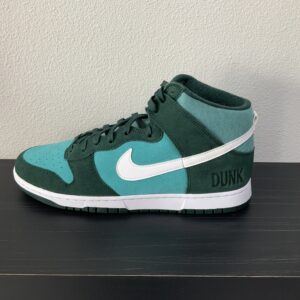 A single teal and white High top Dunk SE (Athletic Club - Pro Green) sneaker displayed on a black shelf against a neutral background.