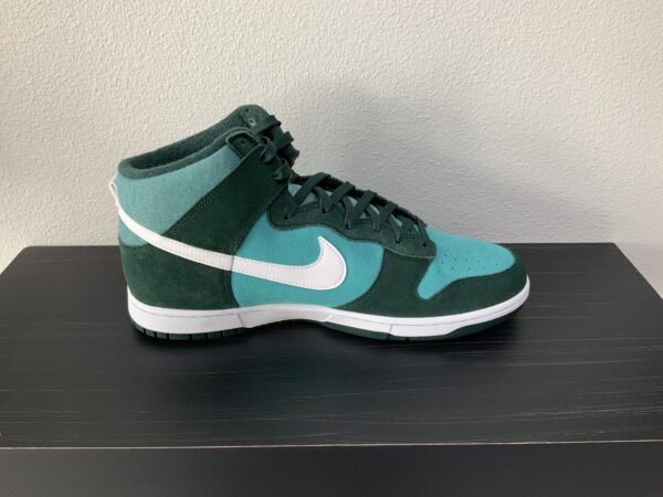 A single High top Dunk SE (Athletic Club - Pro Green) sneaker displayed on a black shelf against a gray wall.