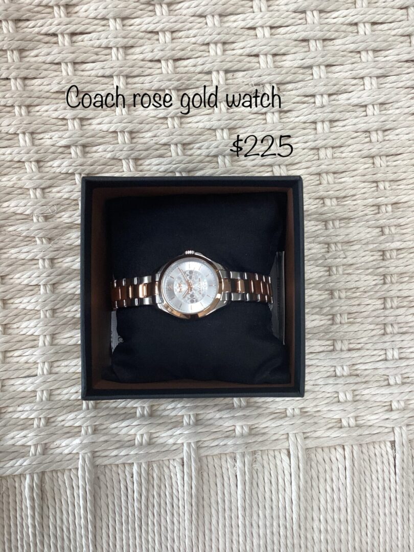 A coach rose gold watch displayed in its box, set against a woven cream background, priced at $225.