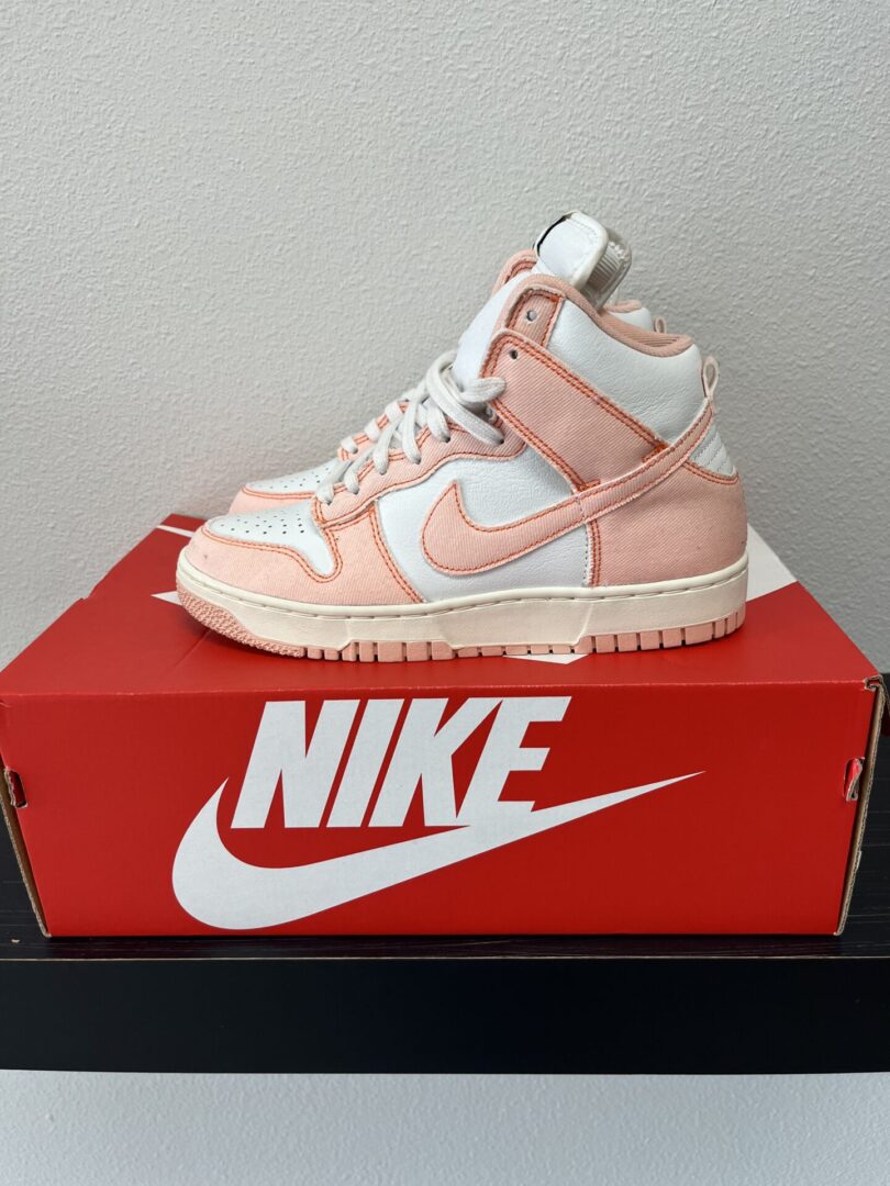 A pink Dunk High Orange high-top sneaker displayed on top of its red Dunk High Orange shoebox with a large white logo on the side.